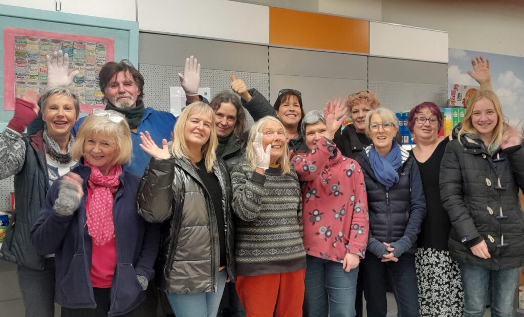 A group of people smiling and waving